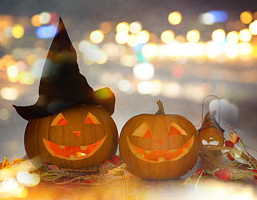 holidays, halloween party and decoration concept - close up of carved pumpkins on table