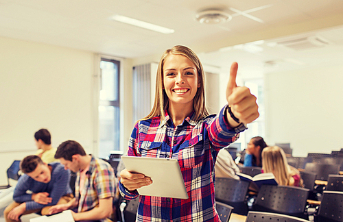 education, high school, teamwork and people concept - group of smiling students with tablet pc computer howing thumbs up in lecture hall