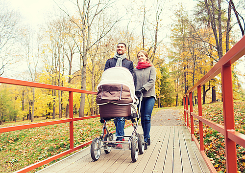 love, parenthood, family, season and people concept - smiling couple with baby pram in autumn park