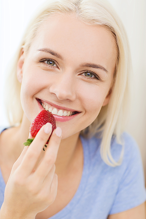 healthy eating, food, fruits, weight loss and people concept - happy woman eating strawberry at home