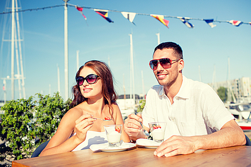 love, dating, people and food concept - smiling couple wearing sunglasses eating dessert at cafe