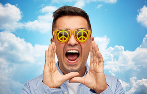 summer, emotions, communication and people concept - face of angry middle aged man in sunglasses with green peace symbol over blue sky and clouds background