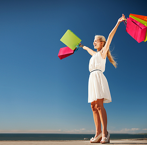 shopping and tourism concept - woman with shopping bags