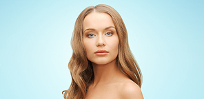 beauty, people, hair care and health concept - beautiful young woman face over blue background