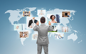 business, people, communication, technology and connection concept - businessman working with world map and images on virtual screen over blue background from back