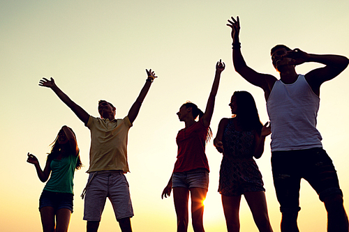 friendship, summer vacation, holidays, party and people concept - group of smiling friends dancing on beach