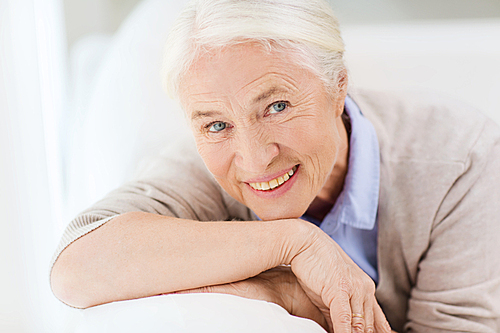 age and people concept - happy smiling senior woman face at home