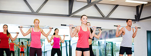 fitness, sport, training, gym and lifestyle concept - group of smiling people working out with barbells in the gym