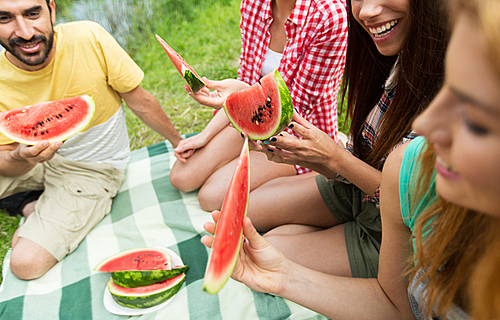 travel, tourism, hike, picnic and people concept - close up of of happy friends with tent eating watermelon at camping
