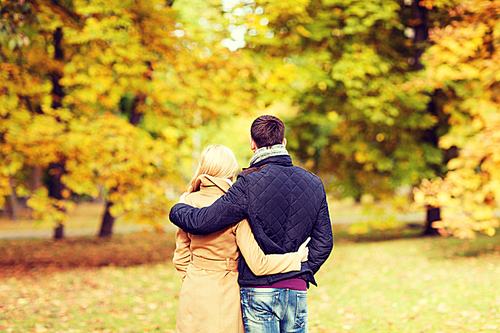 love, relationship, family and people concept - couple hugging in autumn park from back