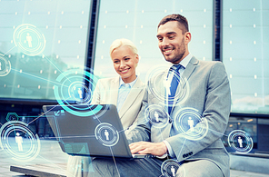 business, communication, technology and people concept - smiling businesspeople working with laptop computer and network projection on city street