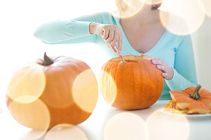 holidays, , decoration and people concept - close up of woman with pumpkins at home