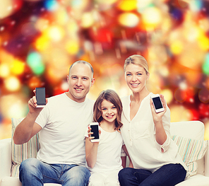 holidays, technology, advertisement and people concept - smiling family with smartphones over red lights background