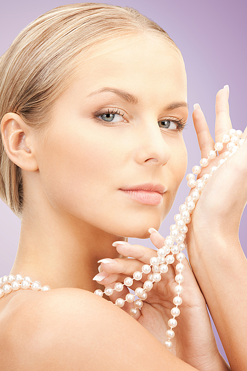 beauty, luxury, people, advertisement and jewelry concept - beautiful woman with sea pearl necklace or beads in hand over violet background