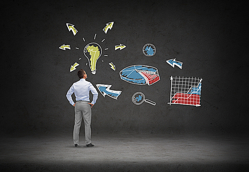 business, people, startup and strategy concept - businessman looking at business idea scheme over concrete room background from back