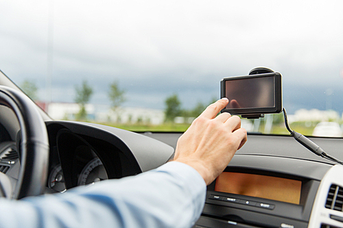 transport, business trip, technology, navigation and people concept - close up of male hand using gps navigator while driving driving car