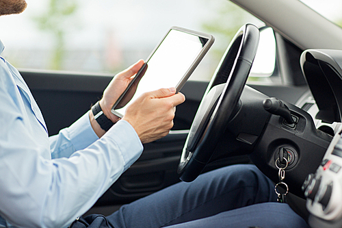 transport, business trip, technology and people concept -close up of young man with tablet pc computer driving car