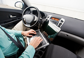 transport, business trip, destination, technology and people concept -close up of young man with laptop computer driving car