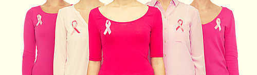 healthcare, people and medicine concept - close up of women in blank shirts with pink breast cancer awareness ribbons over white background