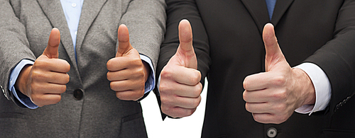 business and office concept - businessman and businesswoman showing thumbs up