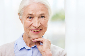 age and people concept - happy smiling senior woman face at home