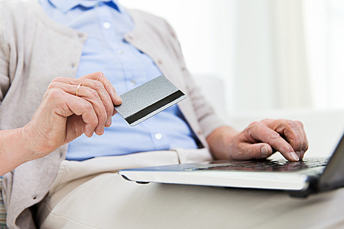 technology, age and people concept - close up of senior woman with laptop compute and credit or bank card r at home