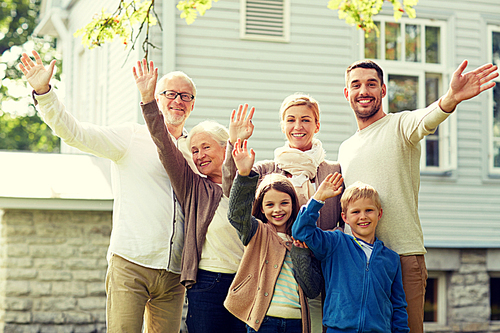 gesture, happiness, generation, home and people concept - happy family waving hands in front of house outdoors