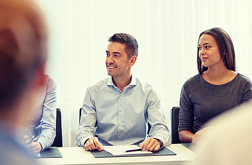 business, people and teamwork concept - group of smiling businesspeople meeting on presentation in office