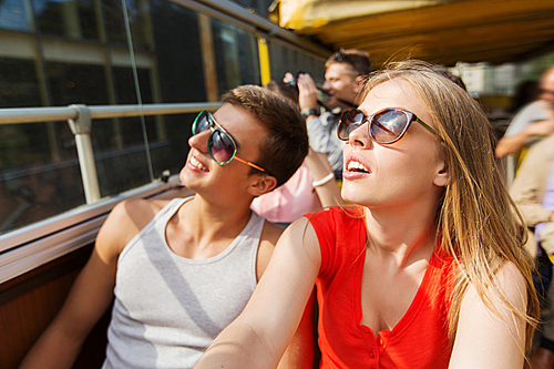 travel, tourism, summer vacation, sightseeing and people concept - happy teenage couple in sunglasses traveling by tour bus