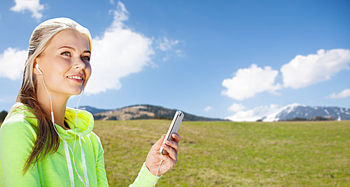 sport, people, fitness, technology and lifestyle concept - woman with smartphone and earphones doing sports and listening to music over natural background