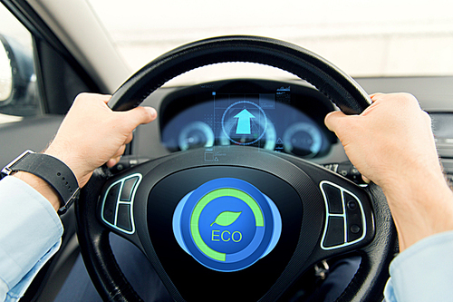 transport, business trip, technology and people concept - close up of male hands holding car wheel and driving in eco mode