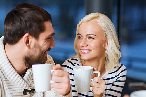 people, leisure, communication, eating and drinking concept - happy couple meeting and drinking tea or coffee at cafe