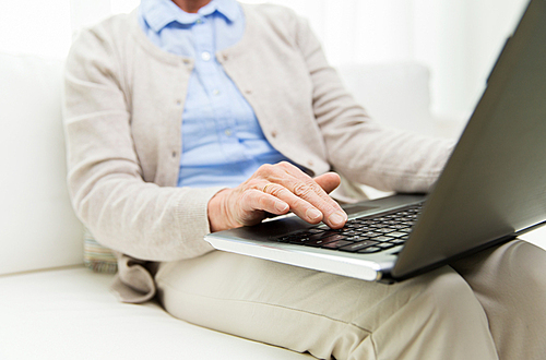 technology, age and people concept - close up of senior woman with laptop computer at home