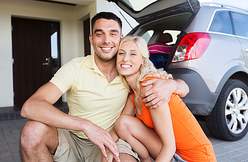 transport, leisure, family and people concept - happy couple hugging at home car parking space