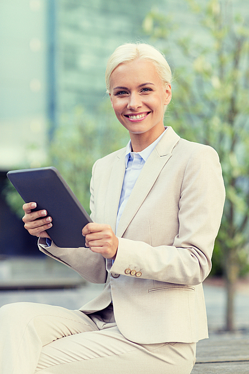 business, education, technology and people concept - smiling businesswoman working with tablet pc computer on city street