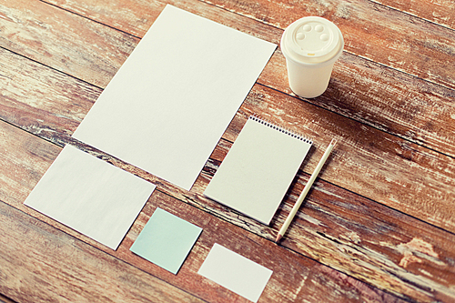 business, education and objects concept - close up of notebook, coffee cup , pencil and papers on table