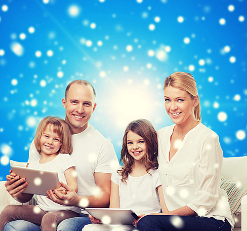 family, holidays, christmas technology and people - smiling mother, father and little girls with tablet pc computers over blue snowy background