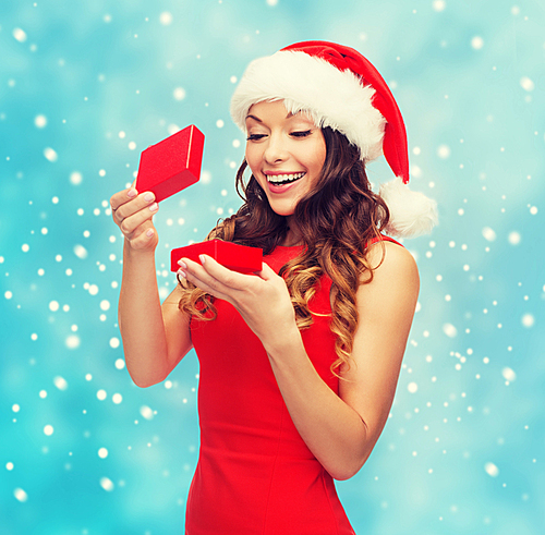 christmas, x-mas, winter, happiness concept - smiling woman in santa helper hat with gift box