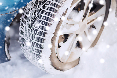 transportation, winter and vehicle concept - closeup of car wheel