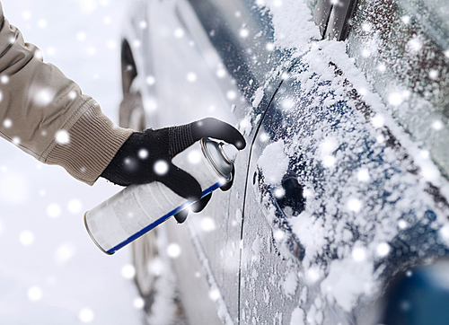 transportation, winter, people and vehicle concept - closeup of man hand with lock door de-icer