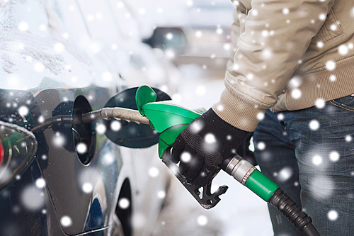 transportation, tanking, people and vehicle concept - close up of man with fuel hose nozzle tanking car