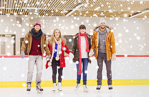 people, friendship, sport and leisure concept - happy friends on skating rink