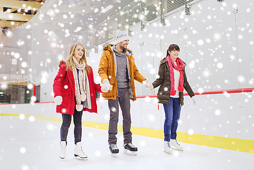 people, friendship, sport and leisure concept - happy friends on skating rink