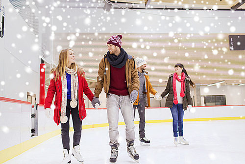 people, friendship, sport and leisure concept - happy friends on skating rink