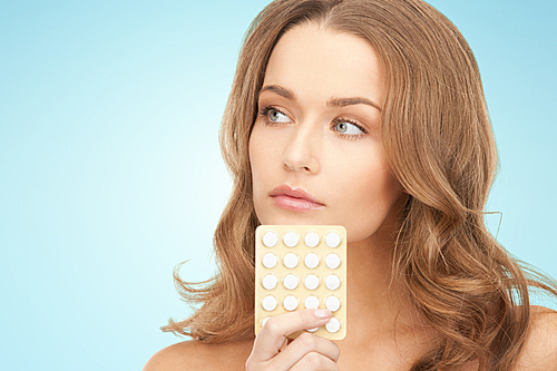 beauty, people, medicine and health care concept - beautiful young woman with medication over blue background