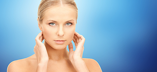 beauty, people and health care concept - beautiful young woman touching her neck over blue background