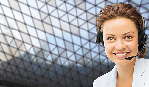 business, people, technology and communication concept - happy female helpline operator in headset over glass ceiling background