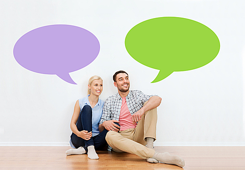 home, people, repair, moving and real estate concept - happy couple of man and woman sitting on floor at new place with empty blank text bubbles