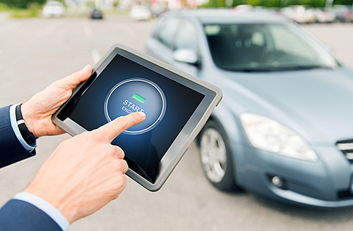 transport, business trip, technology and people concept - close up of male hands pushing start engine button on tablet pc computer screen with car outdoors