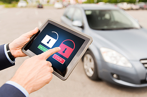 transport, safety, security, technology and people concept - close up of male hands with lock icons on tablet pc computer screen and car outdoors